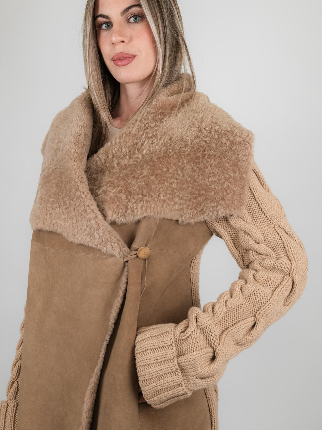 Cappotto in pelle e maglia con trecce beige