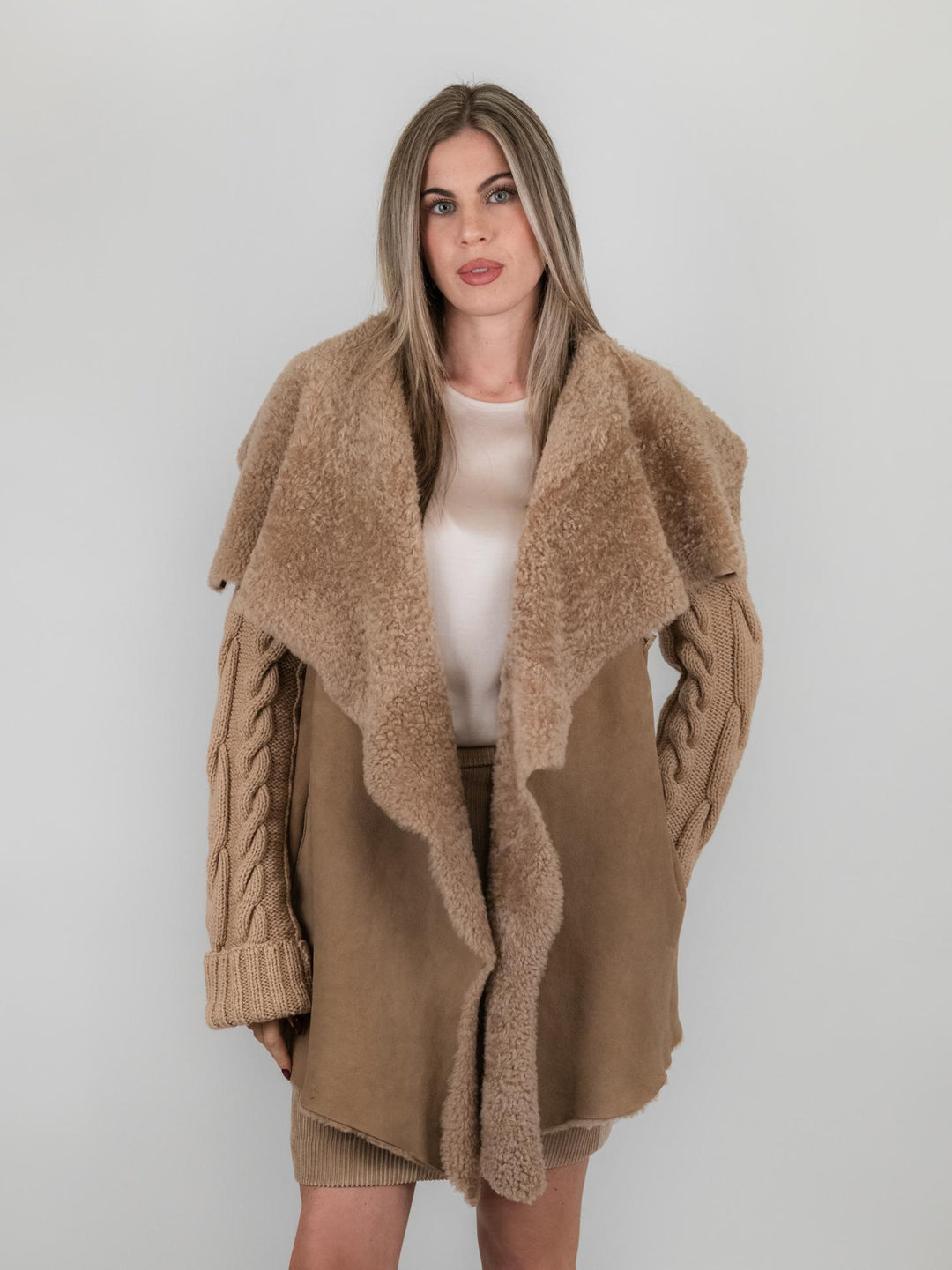 Cappotto in pelle e maglia con trecce beige